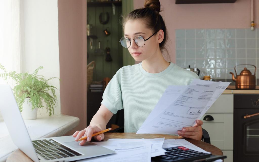 Young lady scrutinizing invoices - Copyright iStock-100147983